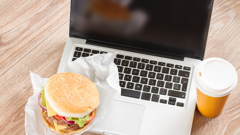 Una computadora con comida en un costado.