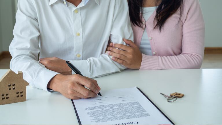 Una pareja firmando un contrato.