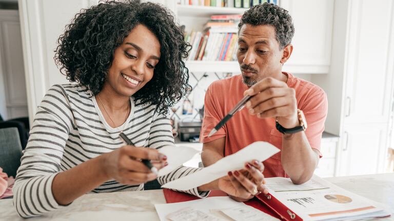 Una pareja sonriendo haciendo finanzas.