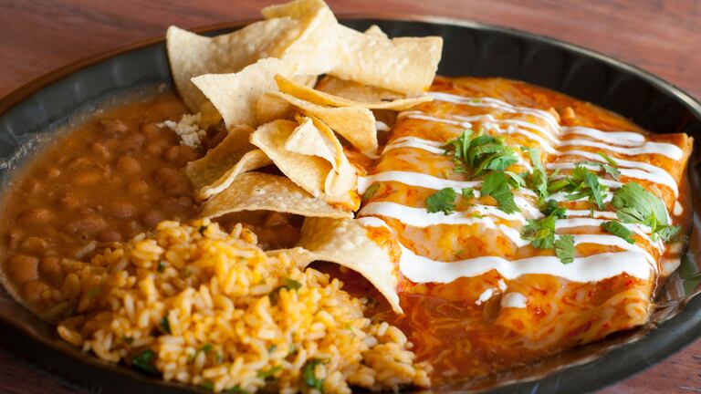 Unas ricas enchiladas con arroz, frijoles y totopos.