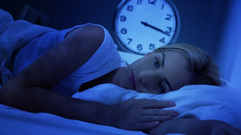 Una mujer que acostada porque no puede dormir.