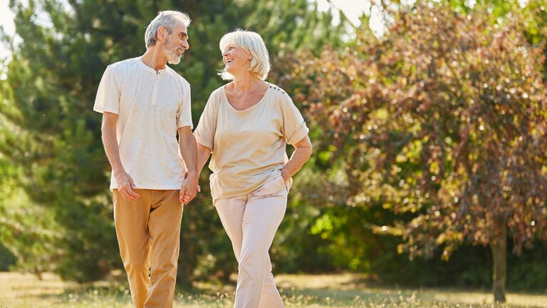 Un hombre y una mujer disfrutando de una caminata en el parque.
